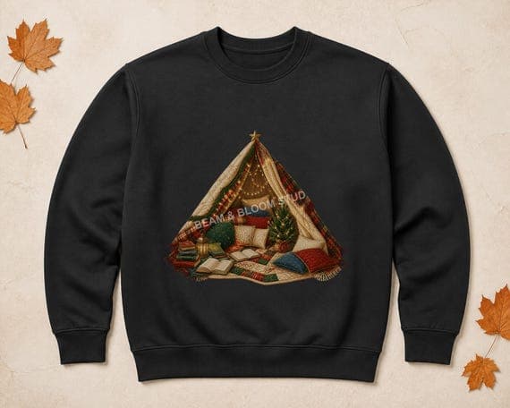 Christmas blanket fort reading nook PNG printed centrally on a black sweatshirt mockup.