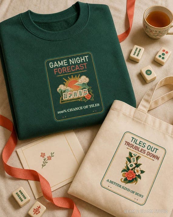 Game Night Forecast and Tiles Out Troubles Down designs shown on a green sweatshirt and cream tote.